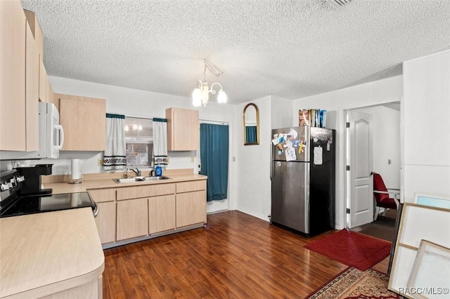 kitchen with sink, stainless steel fridge, light brown cabinetry, dark hardwood / wood-style flooring, and range