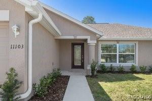 doorway to property with a yard and a garage