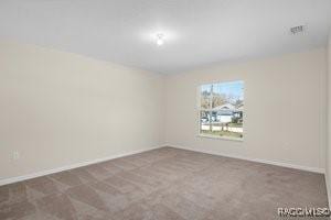 unfurnished room with dark colored carpet