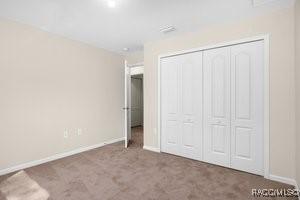 unfurnished bedroom featuring carpet flooring and a closet