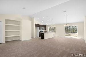 unfurnished living room featuring built in shelves, carpet floors, and vaulted ceiling