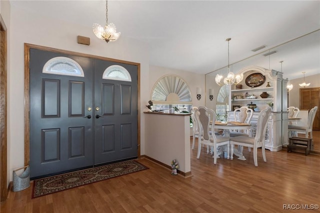 foyer featuring visible vents, a notable chandelier, and wood finished floors