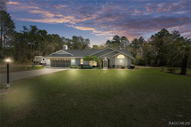 ranch-style house featuring an attached garage, concrete driveway, and a front yard