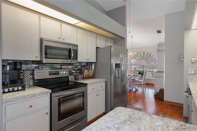 kitchen with tasteful backsplash, visible vents, a chandelier, wood finished floors, and stainless steel appliances