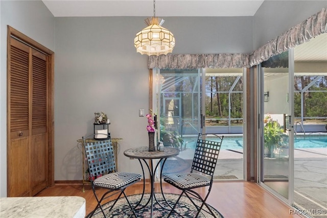 dining space with baseboards and wood finished floors