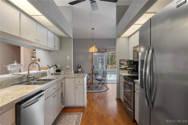 kitchen featuring light wood finished floors, ceiling fan, light countertops, appliances with stainless steel finishes, and a sink