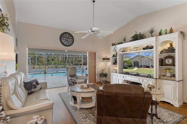 living area with lofted ceiling, wood finished floors, and ceiling fan