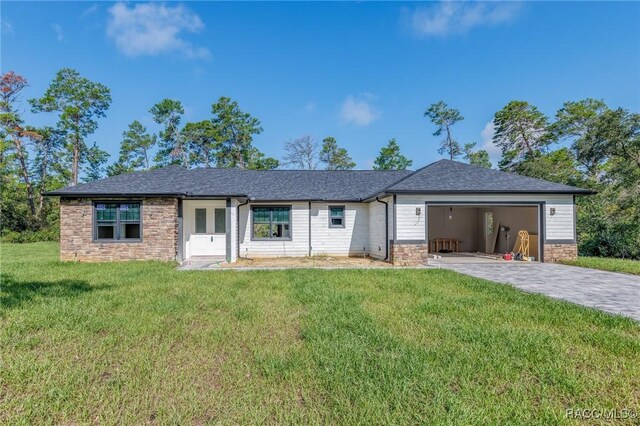 5898 N Flagstaff Ave, Beverly Hills, FL 34465 - ranch-style house with stone siding, a garage, a front yard, driveway, and a shingled roof