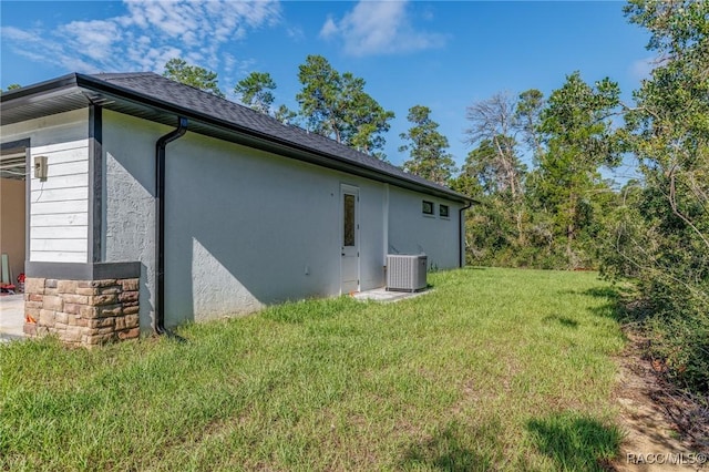 5898 N Flagstaff Ave, Beverly Hills, FL 34465 - view of side of home with a yard, stucco siding, and a shingled roof