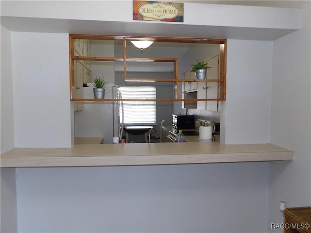 kitchen featuring black microwave and light countertops