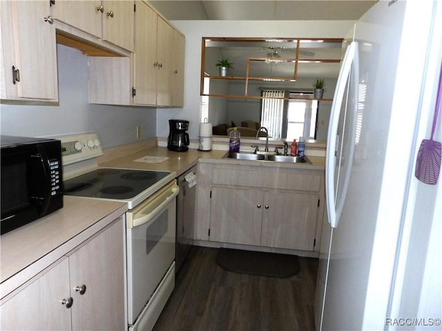 kitchen featuring electric stove, light countertops, light brown cabinets, black microwave, and a sink