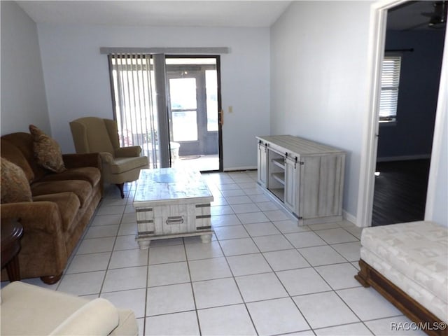 living area featuring baseboards and light tile patterned floors