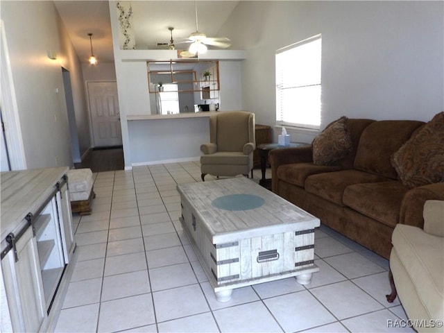 living room with vaulted ceiling, a ceiling fan, and light tile patterned flooring