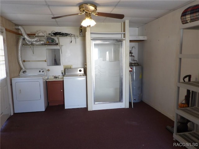 laundry area featuring washing machine and dryer, a sink, a ceiling fan, water heater, and cabinet space