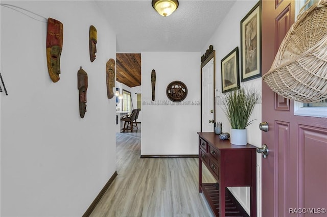 hall featuring light hardwood / wood-style flooring and a textured ceiling