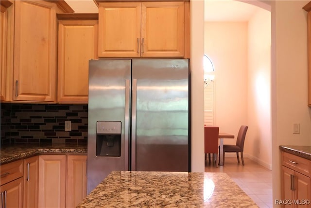 1366 N Bellamy Pt, Hernando, FL 34442 - kitchen featuring backsplash, arched walkways, tile patterned flooring, stainless steel fridge, and dark stone counters