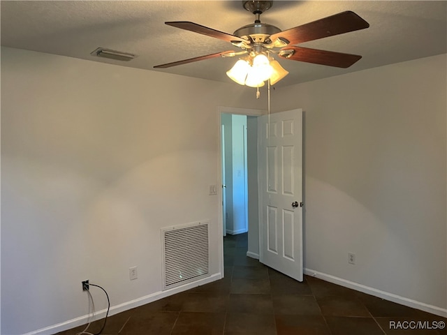 tiled spare room with ceiling fan and a textured ceiling