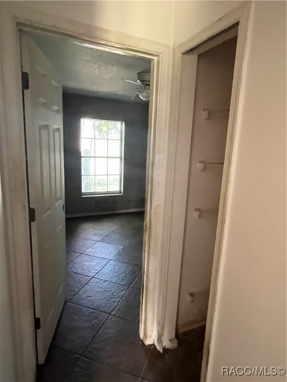 hall featuring dark tile patterned floors