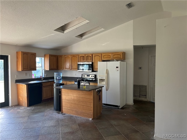 kitchen with sink, stainless steel appliances, high vaulted ceiling, a textured ceiling, and a kitchen island