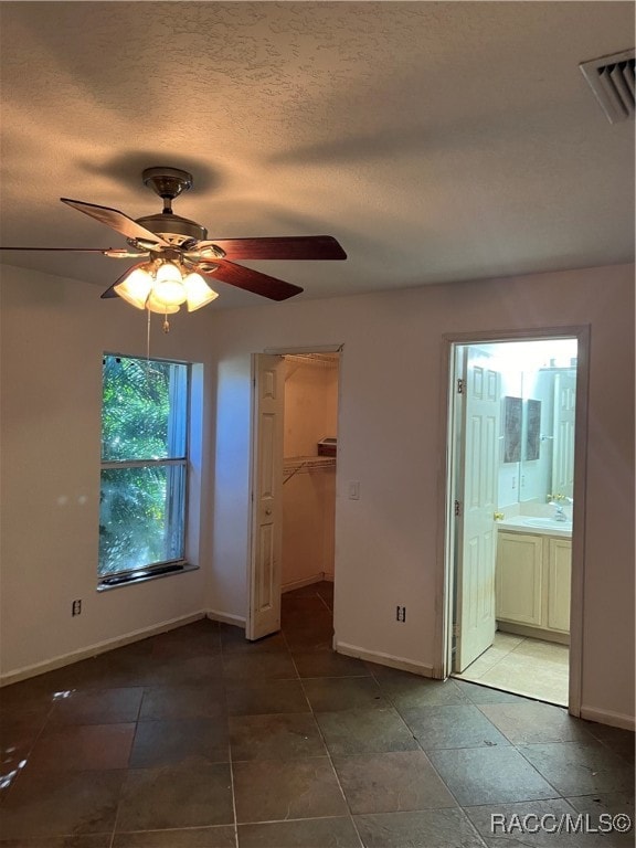 interior space with a textured ceiling, ceiling fan, and sink