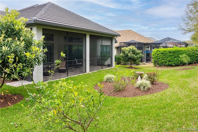 view of yard featuring a patio and glass enclosure