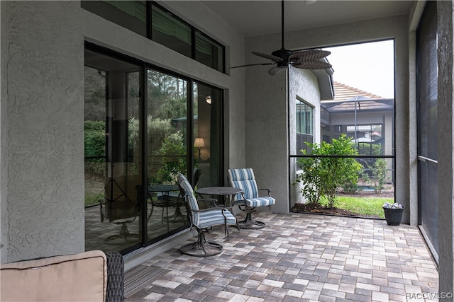 unfurnished sunroom with ceiling fan and a wealth of natural light