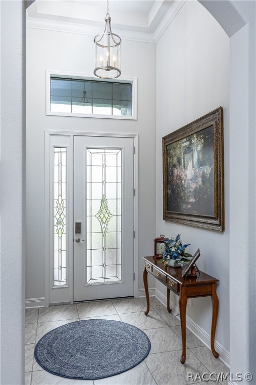 foyer featuring a chandelier and crown molding