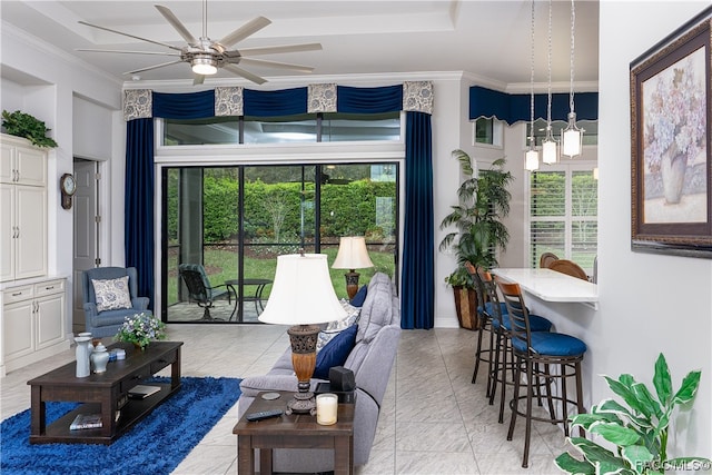 living room featuring ceiling fan with notable chandelier and ornamental molding