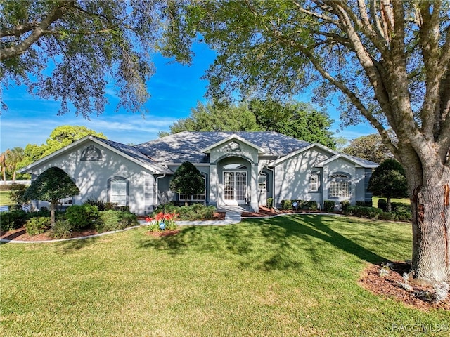 single story home with stucco siding and a front yard
