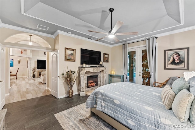 bedroom with crown molding, access to outside, a raised ceiling, french doors, and visible vents