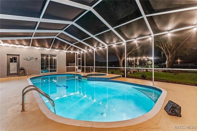 view of pool featuring a patio area, a lanai, and a pool with connected hot tub
