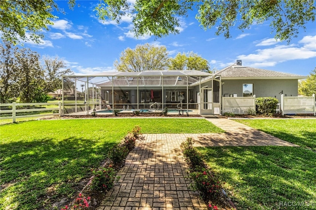 back of property featuring a yard, fence, a fenced in pool, and a patio area