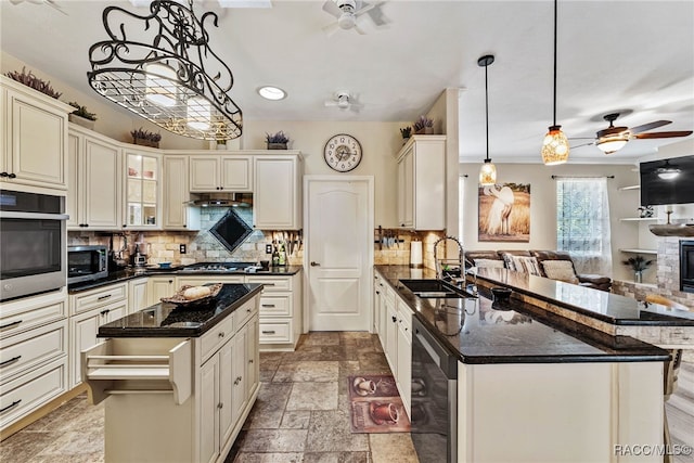 kitchen with a sink, beverage cooler, a ceiling fan, stainless steel appliances, and a peninsula