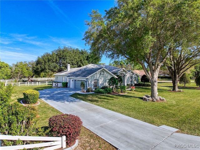 ranch-style home featuring fence, a front lawn, a garage, a chimney, and driveway