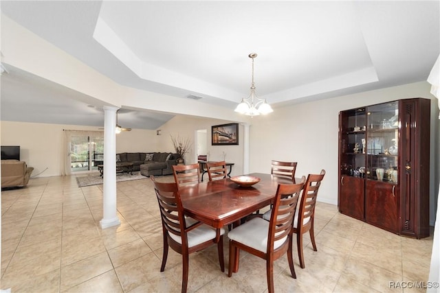 tiled dining room with decorative columns, a chandelier, and a tray ceiling