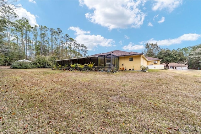 view of side of property featuring glass enclosure and a lawn