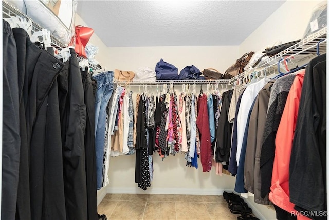 spacious closet with light tile patterned floors