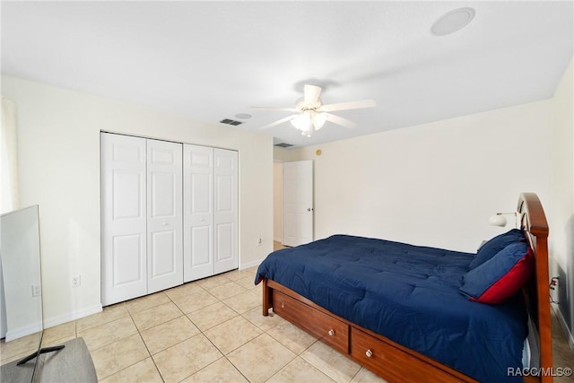 tiled bedroom with ceiling fan and a closet