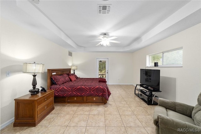 bedroom with light tile patterned flooring, ceiling fan, and a raised ceiling