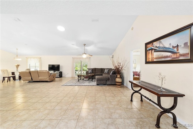 living room featuring ceiling fan, lofted ceiling, and light tile patterned floors