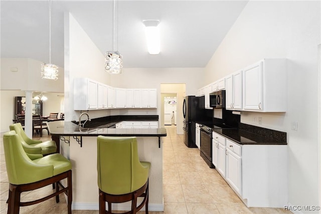 kitchen featuring a breakfast bar, decorative light fixtures, black appliances, kitchen peninsula, and white cabinets