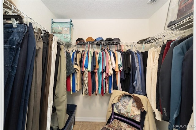 walk in closet with tile patterned floors