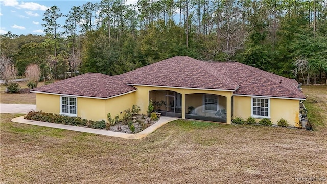 view of front of property with a front lawn and a sunroom