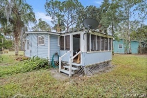 view of front of property with a sunroom and a front yard