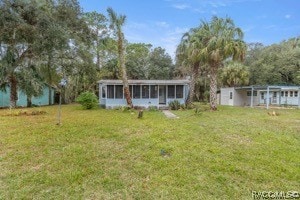 exterior space featuring a front lawn and a sunroom