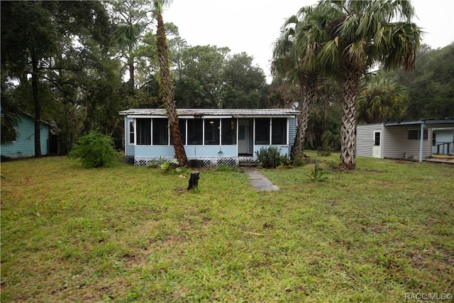 back of property with a lawn and a sunroom