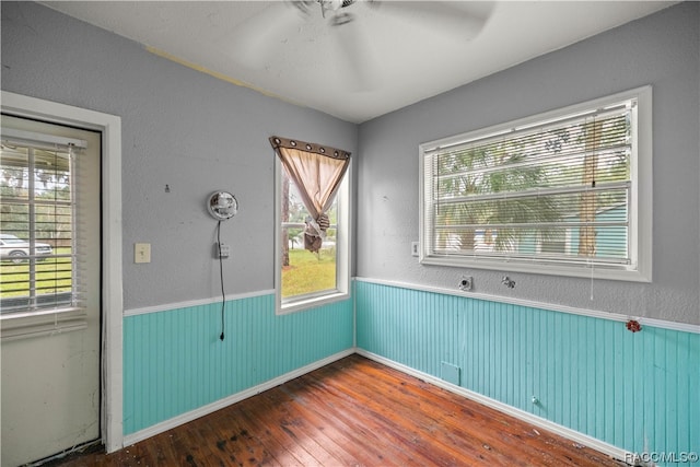 empty room with ceiling fan and hardwood / wood-style floors