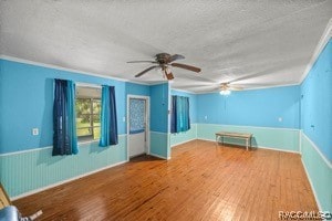 spare room with crown molding, hardwood / wood-style floors, and a textured ceiling