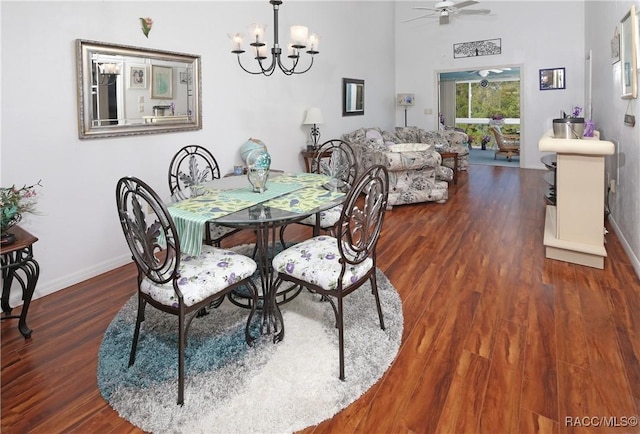 dining area with ceiling fan with notable chandelier and dark wood-type flooring