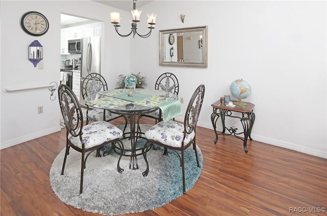 dining area with dark wood-type flooring and a chandelier